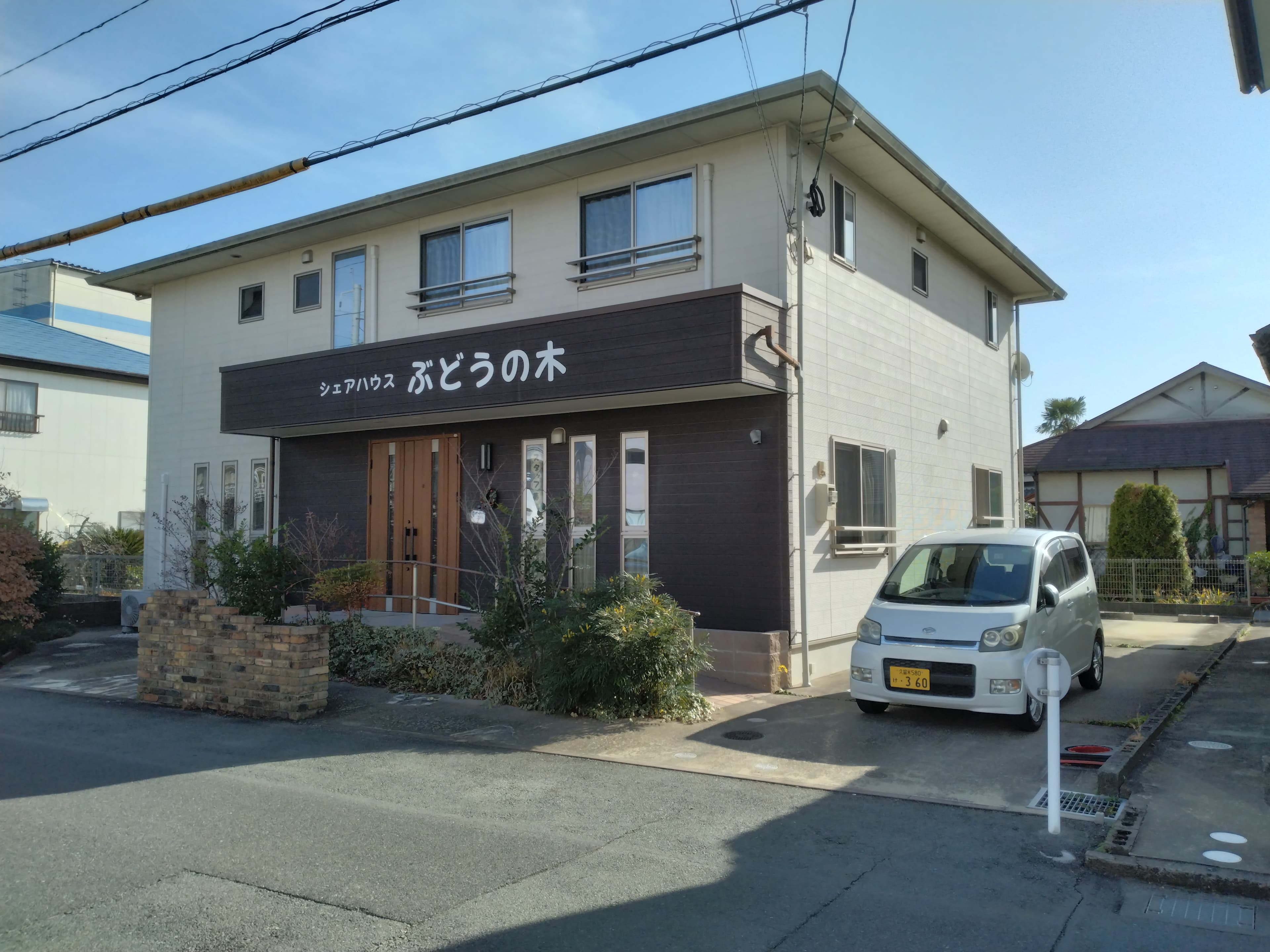 代表が入居者様と一緒に食卓を囲み、同じ目線で笑い合っている自然なスナップ写真